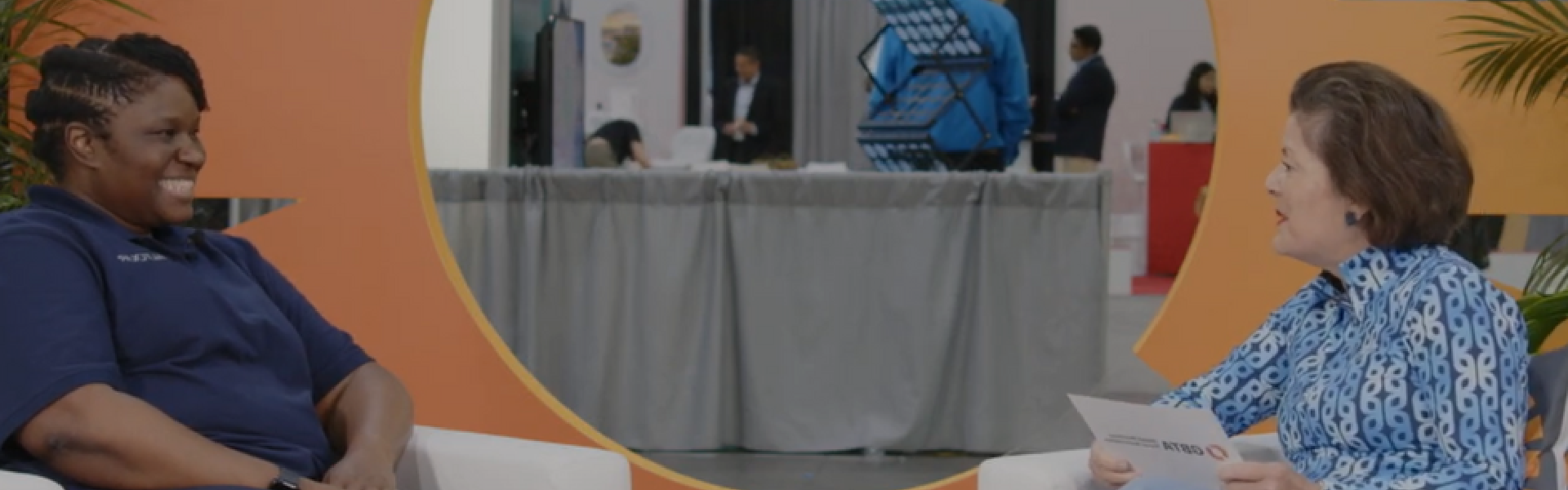 Two woman talking in a event, interview style