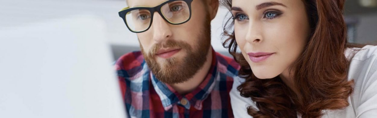 How to Create the Right Travel Policy for your Company 5 A woman and a men reading something from the pc.