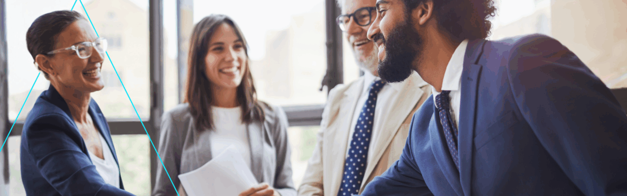 ROI of Business Travel. A group of coworkers in a meeting, smiling.