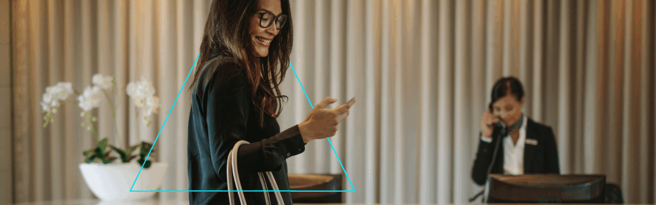 ALTOUR Index Report 2025. Executive woman with a cellphone in a hotel reception.