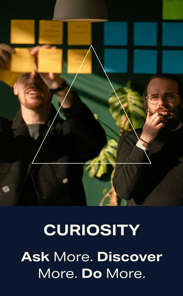Curiosity. Ask more. Discover more. Do more. Two workmates doing a brainstorming on a board.