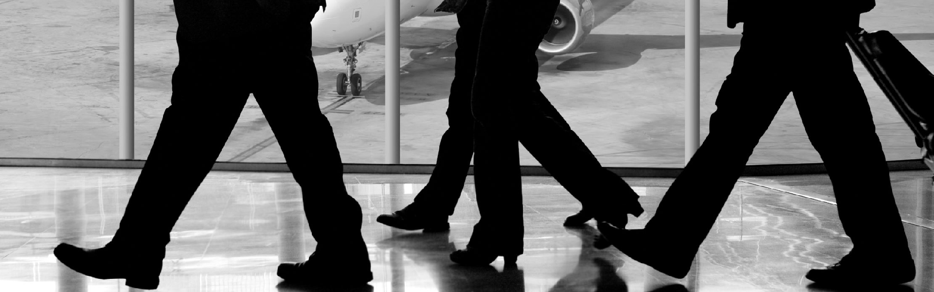 Imagen destacada del artículo sobre políticas de viajes. Se observan pies de personas caminando por el aeropuerto